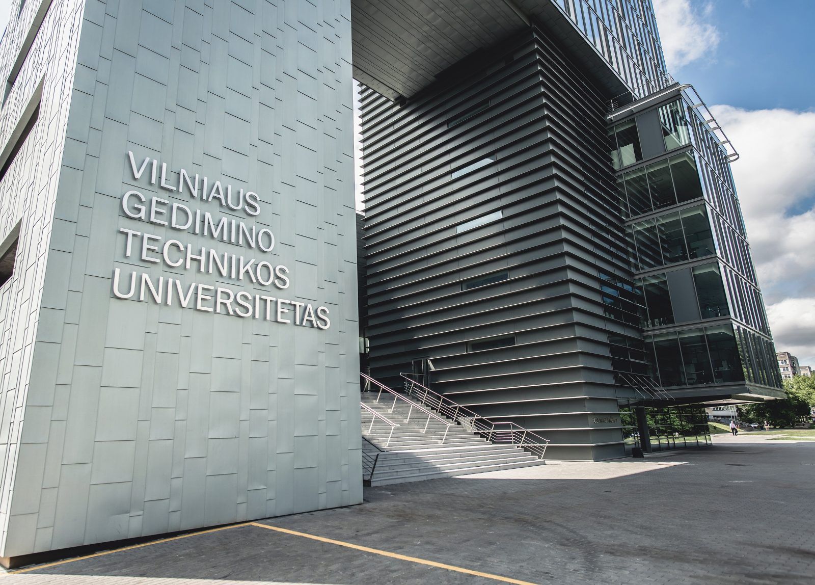 Pilkas modernus pastatas su užrašu „Vilniaus Gedimino technikos universitetas“ ir plačiais laiptais prie įėjimo